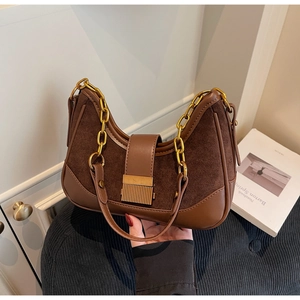 Detail of vintage brown leather hobo bag with contrast stitching and gold chain strap