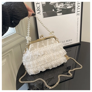 Détail du sac à main en dentelle blanche avec anse en perles et fermoir doré