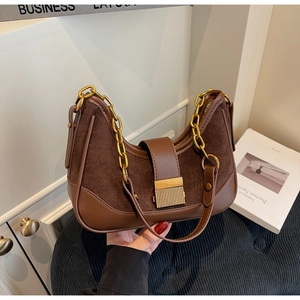 Detail of retro brown suede and leather shoulder bag with vintage gold chain and buckle