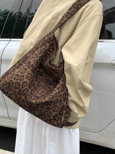 Outdoor street style of a large leopard print canvas tote bag with wide shoulder strap