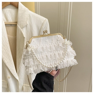 Détail du sac à main élégant en dentelle blanc perle avec fermoir doré et perles de luxe