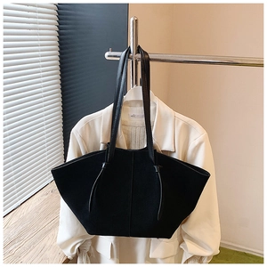 Detail of minimalist black matte tote bag with slim shoulder straps on a hanger