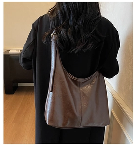 Detail view of a large vintage brown tote bag with high-quality wrinkled texture and stitching