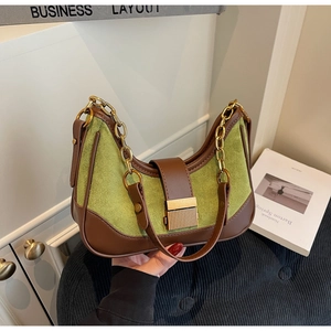 Detail of green suede and brown leather hobo bag with thick gold chain and metal buckle