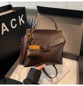 Detail of dark brown retro oil wax leather handbag with square buckle and mini pouch
