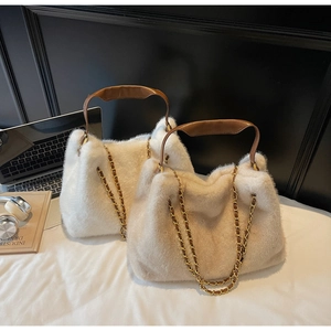 Detail of plush faux fur tote bags in white and beige with metal chain leather straps