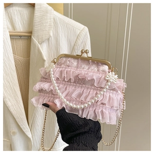 Gros plan du sac à main plissé rose avec poignée en perles et chaîne dorée chic