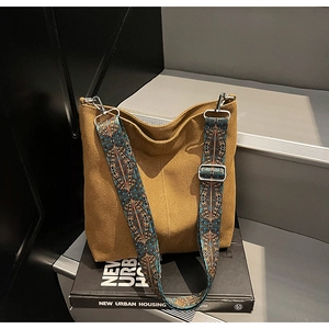 Close-up of ginger canvas bucket bag with ethnic geometric pattern shoulder strap