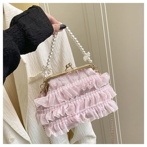 Détail du sac à main en tulle rose à volants avec anse en perles et fermoir en métal doré
