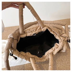 Vue détaillée de l'intérieur d'un cabas matelassé kaki avec fermoir aimanté et poche zippée