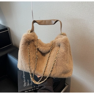 Detail of plush faux fur shoulder bag with leather handle and gold chain strap
