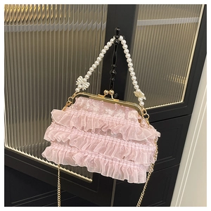 Détail du sac à main rose à volants avec anse en perles et fermoir en métal doré