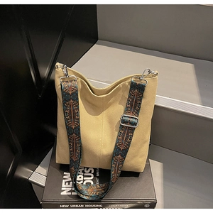 Detail of canvas tote bag featuring an ethnic jacquard wide shoulder strap and metal hooks