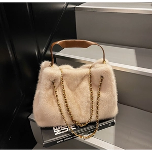 Detail of plush faux mink tote bag with brown leather handle and gold chain strap
