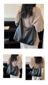 Detail of black glossy leather tote bag showing soft texture and vertical seam stitching