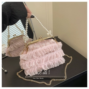 Détail de la texture en gaze plissée rose avec poignée en perles et fermoir en métal doré