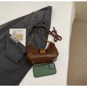 Detail of a brown suede contrast shoulder bag with a gold chain and long leather strap