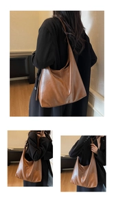 Detail view of large brown faux leather tote bag with glossy texture and wide shoulder strap