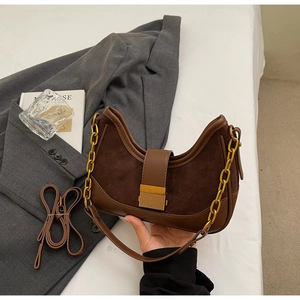 Detail of hobo bag featuring brown PU leather mixed with suede and gold chain strap
