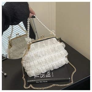 Détail macro du sac en dentelle blanche à volants avec poignée en perles et fermoir métal
