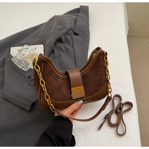 Detail of vintage brown crescent bag featuring gold chain handle and metal buckle