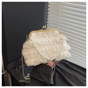 Détail d'un sac à main élégant en dentelle plissée avec perles et chaîne dorée