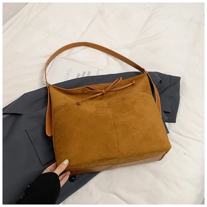 Vue détaillée du sac bandoulière en daim marron avec nœud décoratif et coutures