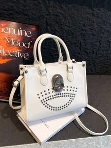 Sac fourre-tout blanc punk avec crâne métallique et rivets argentés sur fond noir élégant