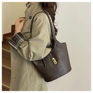 Close-up of dark brown tote bag featuring elegant leather texture and golden metal lock