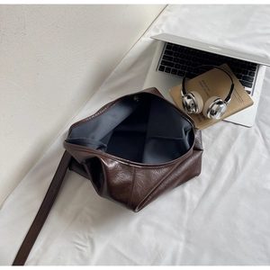 Detail of soft dark brown leather tote with magnetic buckle and grey lining