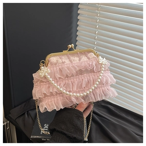 Détail du sac en dentelle rose avec poignée en perles et fermoir doré vintage