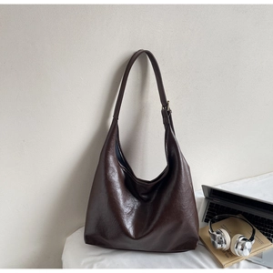 Detailed close-up of dark brown hobo bag showing vintage oil wax leather texture and strap