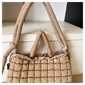 Détails d'un sac cabas matelassé beige en nylon avec cordon de serrage et bandoulière