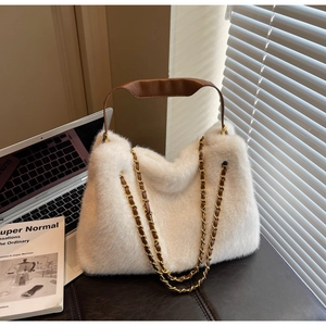 Detail of white faux fur handbag with golden chain straps and brown leather handle