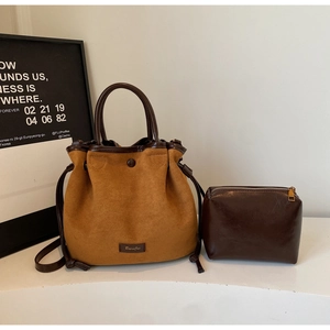Détail du sac seau en daim avec poignée contrastée et pochette assortie