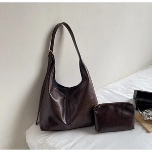 Detail view of large dark brown leather tote bag set with matching small zipper pouch