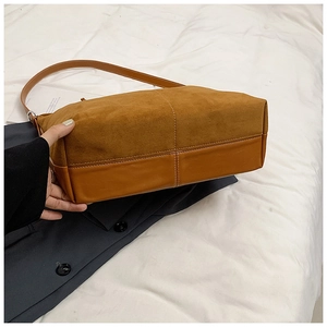 Vue détaillée du sac cabas en cuir mat marron avec surpiqûres blanches et design rétro