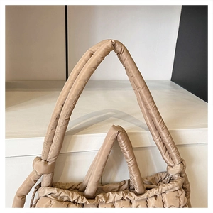 Détail du sac cabas matelassé avec poignées nouées et fermeture par cordon de serrage