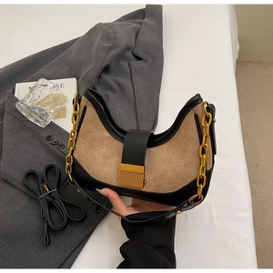Detail of retro half-moon shoulder bag with brown suede, black leather and gold buckle