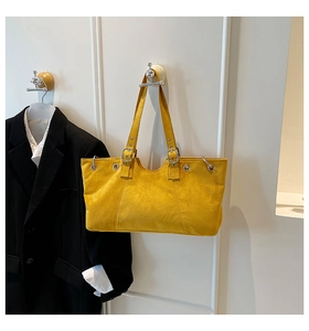 Detail of yellow tote bag with metallic eyelets and sturdy shoulder strap connector