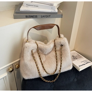 Detail of plush faux fur texture with brown leather handle and gold chain strap