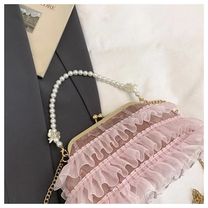 Détail du sac plissé en dentelle rose avec anse en perles et fermoir doré vintage