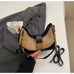 Detail of contrast stitching shoulder bag with gold chain and khaki suede texture