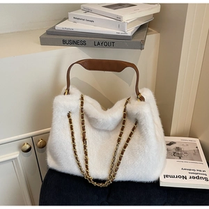 Detailed close-up of fluffy white faux fur texture on a handbag with brown leather handles