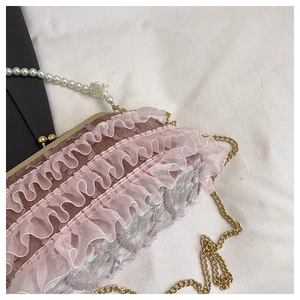 Détails des volants en dentelle rose et fermoir doré d'un sac de soirée avec perles