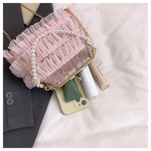 Détail du sac de soirée en dentelle rose avec anse en perles et cadre doré élégant