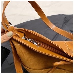 Détails de la doublure en daim et zip argenté sur le sac bandoulière vintage en cuir marron