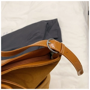 Détail du sac vintage montrant la boucle argentée réglable et les surpiqûres blanches