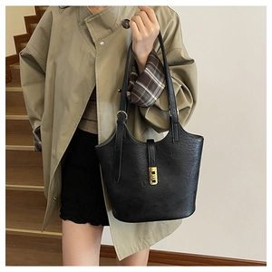 Close-up of black pebble leather tote with elegant gold rectangular twist lock clasp
