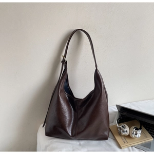 Detail view of coffee hobo bag showing retro oiled leather texture and adjustable strap